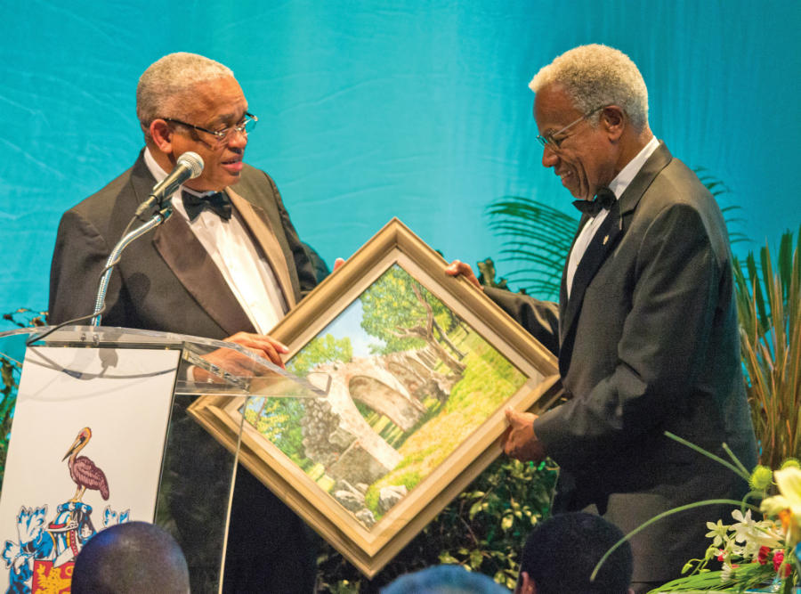 Former Chancellor of The UWI, Professor Emeritus Sir George Alleyne receives a gift at the farewell dinner in his honour.